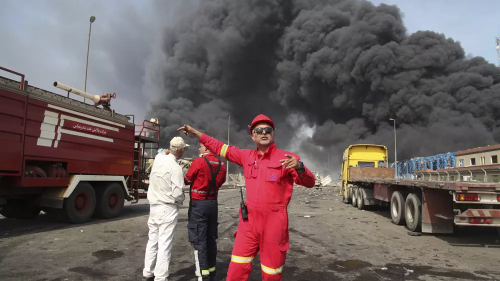 In this photo provided by Islamic Republic News Agency (IRNA) firefighters work as black smoke rises in the sky after a massive explosion rocked a port near the southern city of Bandar Abbas, Iran, Saturday, April 26, 2025. (Mohammad Rasoul Moradi/IRNA via AP)