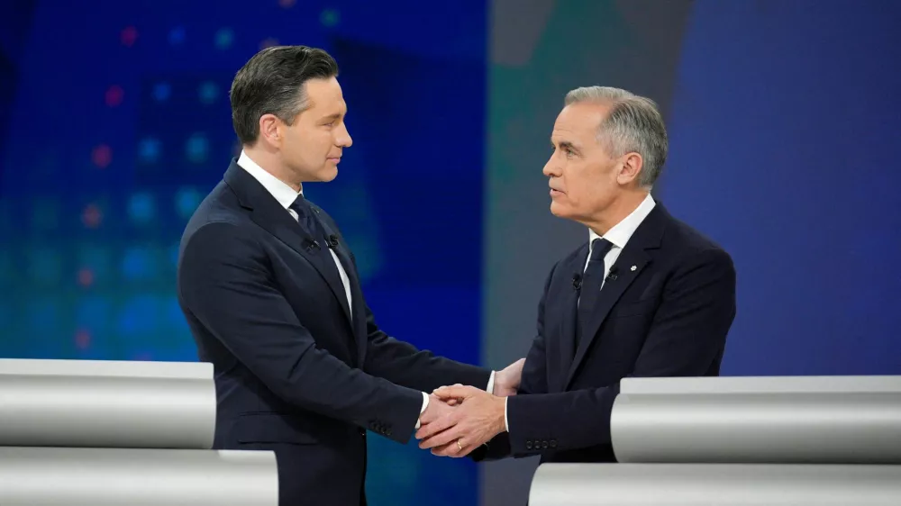 FILE PHOTO: Conservative Leader Pierre Poilievre and Liberal Leader Mark Carney shake hands following the English-language federal leaders' debate in Montreal, Canada, April 17, 2025. Christopher Katsarov/Pool via REUTERS/File Photo