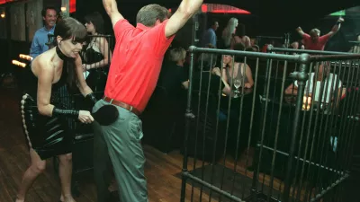 A waitress at La Nouvelle Justine paddles a customer at the S&M restaurant in New York Monday night, Aug. 11, 1997. The customer, who declined to give his name, was treated to the  spanking from the "special menu" by friends who took him to the restaurant after his bachelor party earlier in the evening. (AP Photo/Emile Wamsteker)