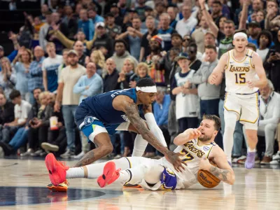 Apr 27, 2025; Minneapolis, Minnesota, USA; Los Angeles Lakers guard Luka Doncic (77) calls a timeout after stumbling on the defense of Minnesota Timberwolves forward Jaden McDaniels (3) in the fourth quarter during game four of first round for the 2025 NBA Playoffs at Target Center. Mandatory Credit: Matt Blewett-Imagn Images
