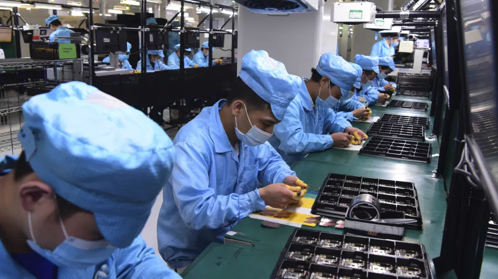 In this Feb. 13, 2020, photo released by Xinhua News Agency, workers wearing masks labor at a factory for Chinese telecommunications company OPPO in Dongguan, in southern China's Guangdong Province. Factories in China, struggling to reopen after the coronavirus shut down the economy, face a new threat from U.S. anti-disease controls that might disrupt the flow of microchips and other components they need. For most people, the new coronavirus causes only mild or moderate symptoms. For some it can cause more severe illness. (Chen Yuxuan/Xinhua via AP)