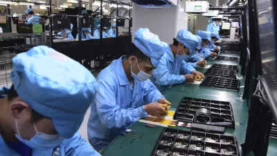 In this Feb. 13, 2020, photo released by Xinhua News Agency, workers wearing masks labor at a factory for Chinese telecommunications company OPPO in Dongguan, in southern China's Guangdong Province. Factories in China, struggling to reopen after the coronavirus shut down the economy, face a new threat from U.S. anti-disease controls that might disrupt the flow of microchips and other components they need. For most people, the new coronavirus causes only mild or moderate symptoms. For some it can cause more severe illness. (Chen Yuxuan/Xinhua via AP)