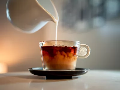 A close-up shot of a poring milk in a hot tea. / Foto: Wirestock