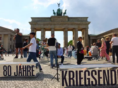 People walk beside mirrored blocks reading, "80 years of the end of the war", in front of Brandenburg Gate to mark the end of World War Two in Europe 80 years ago in Berlin, Germany, May 2, 2025. REUTERS/Fabrizio Bensch