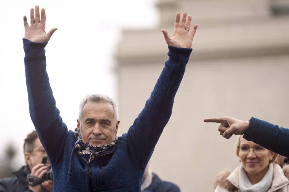 FILE - Calin Georgescu, the winner of the first round of presidential elections, later annulled by the Constitutional Court, waves to supporters during a protest, in Bucharest, Romania, March 1, 2025. (AP Photo/Vadim Ghirda, File)