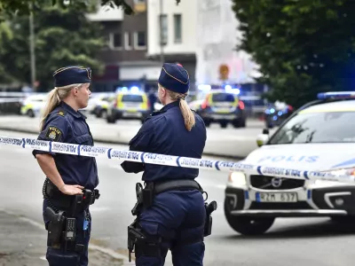 Police stand next to a cordon in central Malmo, southern Sweden, Monday, June 18, 2018. A Swedish newspaper is reporting that four people have injured in a shooting near a police station in the southern city of Malmo. Witnesses told newspaper Aftonbladet they heard what sounded like 15 to 20 shots about 6:15 p.m. in the city center.(Johan Nilsson/TT News Agency via AP)
