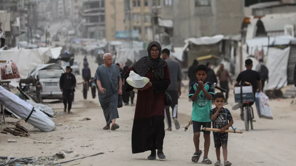 30 April 2025, Palestinian Territories, Gaza: Palestinians walk amidst dust during a sand storm in Gaza City. The UN food agency, one of the main providers of food assistance in the besieged Palestinian territory said on April 25 it had "delivered its last remaining food stocks to hot meals kitchens in the Gaza Strip", where Israel has blocked all aid for months, adding "these kitchens are expected to fully run out of food in the coming days". Photo: Omar Ashtawy/APA Images via ZUMA Press Wire/dpa