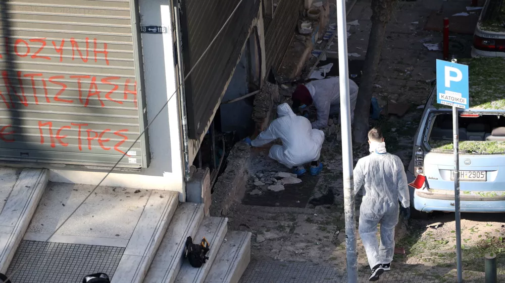 Forensics officers investigate the area of a blast caused by an explosive device outside a bank that killed a 38-year old woman, in Thessaloniki, Greece, May 3, 2025. REUTERS/Alexandros Avramidis