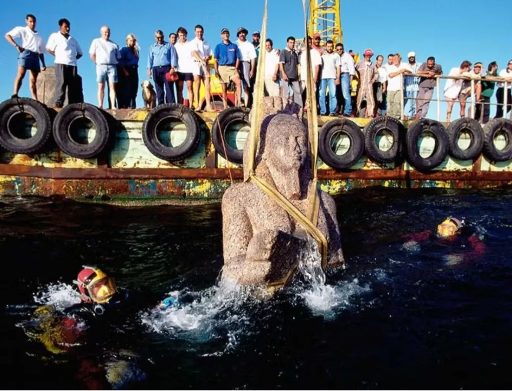 Franck Goddio in njegova ekipa opazujejo dvig kolosalnega kipa iz rdečega granita (5,4 m), ki predstavlja boga Hapija, simbol obilja in plodnosti ter boga poplav Nila, na povr&scaron;je. Kip boga te velikosti &scaron;e nikoli prej ni bil odkrit v Egiptu. Foto: Christoph Gerigk &copy;Franck Goddio/Hilti Foundation