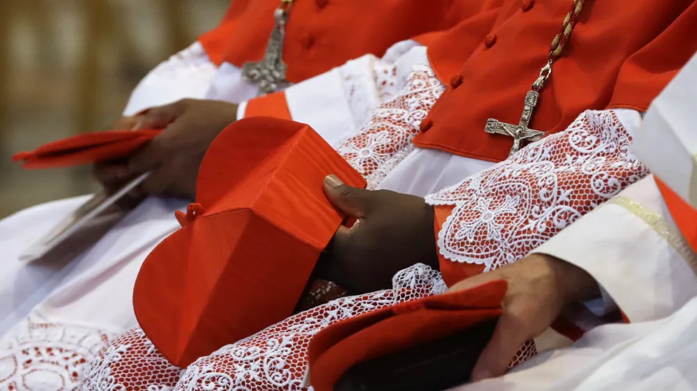 FILE - Cardinals hold the red three-cornered biretta hats before a consistory inside the St. Peter's Basilica at the Vatican, Saturday, Nov. 19, 2016. (AP Photo/Gregorio Borgia, File)
