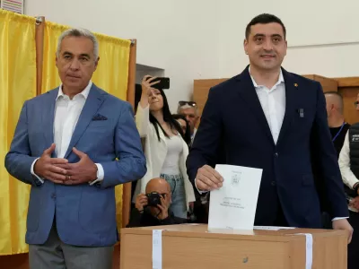Presidential candidate George Simion votes as Calin Georgescu looks on at a polling station during the country's first round of the presidential election, in Mogosoaia, Romania, May 4, 2025. REUTERS/Louisa Gouliamaki