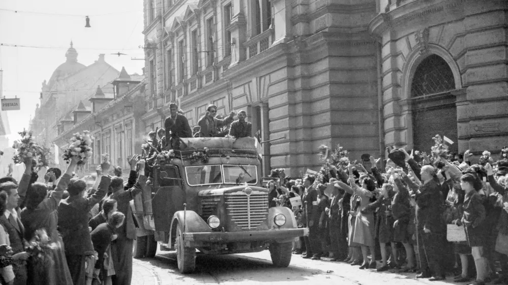Množica s cvetjem pozdravlja partizansko vojsko, nekateri so se pripeljali s tovornjaki, Ljubljana, 9. maj 1945. Fotografija: Rudi Stopar, hrani Muzej novej&scaron;e in sodobne zgodovine SlovenijePOZOR, NI ZA PONOVNO OBJAVO BREZ DOVOLJENJA MNSZS!!!