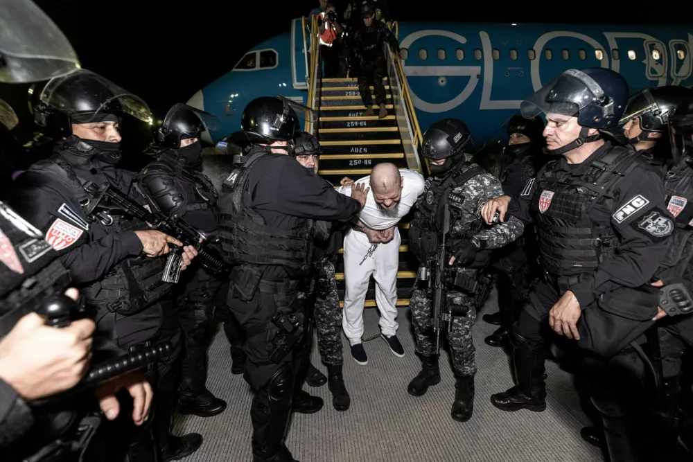 Salvadoran police officers escort an alleged member of the Venezuelan gang Tren de Aragua recently deported by the U.S. government to be imprisoned in the Terrorism Confinement Center (CECOT) prison, as part of an agreement with the Salvadoran government, in Tecoluca, El Salvador, in this handout image obtained March 16, 2025. Secretaria de Prensa de la Presidencia/Handout via REUTERS ATTENTION EDITORS - THIS IMAGE HAS BEEN SUPPLIED BY A THIRD PARTY. NO RESALES. NO ARCHIVES