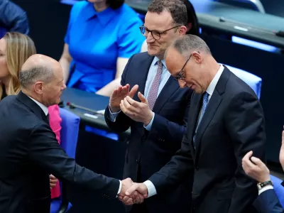 06 May 2025, Berlin: Acting German Chancellor Olaf Scholz shakes hands with Chancellor candidate Friedrich Merz during the second round of Chancellor election. Merz failed the first round of voting in the Bundestag. Photo: Kay Nietfeld/dpa