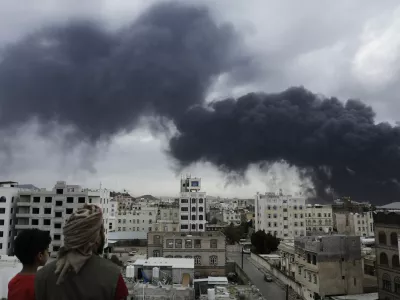 Yemenis watch as smoke billows following Israeli airstrikes targeting a power plant and Sanaa Airport, in Sanaa, Yemen, Tuesday, May 6, 2025. (AP Photo/Osamah Abdulrahman)