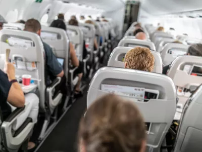 Interior of commercial airplane with passengers in their seats during flight.