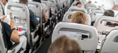 Interior of commercial airplane with passengers in their seats during flight.