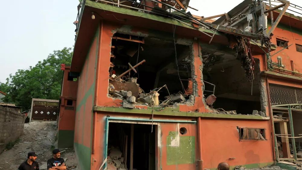 Police officers look on as a cameraman films the Bilal Mosque, after it was hit by an Indian strike in Muzaffarabad, the capital of Pakistan-administered Kashmir, May 7, 2025. REUTERS/Akhtar Soomro