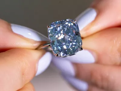 A Sotheby's staff holds "The Mediterranean Blue", a fancy vivid blue diamond weighing 10.03 carats estimated to reach 20 million Swiss francs during an auction preview in Geneva, Switzerland, May 8, 2025. REUTERS/Denis Balibous