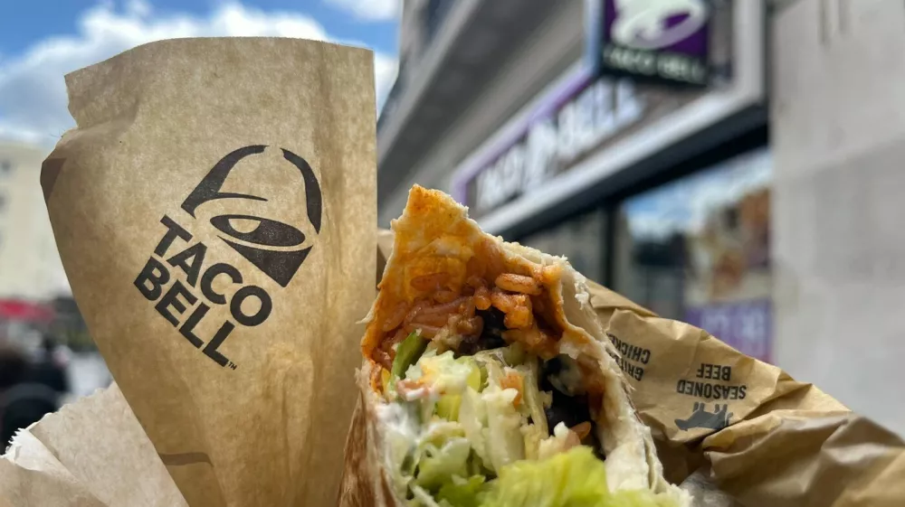 15 May 2024, Great Britain, London: The Taco Bell logo and a burrito can be seen outside a branch of the chain in London. The US fast food chain Taco Bell is expanding into the German market. The first restaurant will open in Berlin this summer, with more to follow. Photo: Julia Kilian/dpa,Image: 873190726, License: Rights-managed, Restrictions: GERMANY OUT, Model Release: no