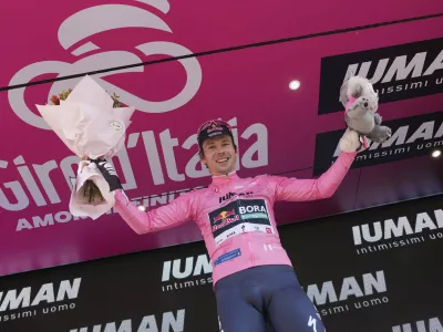 Slovenia's Primoz Roglic celebrates on the podium after earning the pink jersey of overall leader after the time trial stage 2 of the Giro d'Italia cycling race, in Tirana, Albania, Saturday, May 10, 2025. (Gian Mattia D'Alberto/LaPresse via AP)