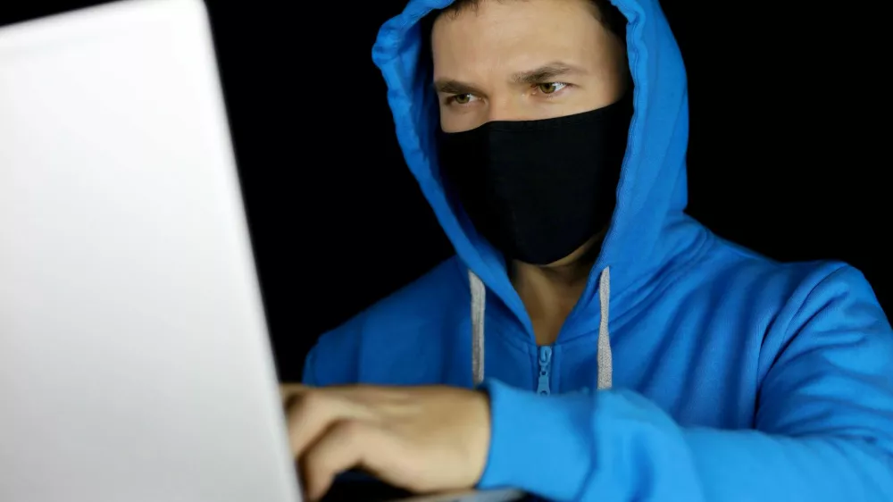 Mo&scaron;ki za računalnikom z masko na obrazu