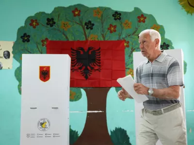 A man walks at a polling station during parliamentary election in Tirana, Albania, May 11, 2025. REUTERS/Florion Goga