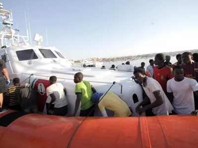 Migrants prepare to disembark in the island of Lampedusa, Italy, Wednesday, Aug. 7, 2013, after being rescued at sea by the Italian Coast Guard. Thousands of migrants heading to Europe arrive in Malta and Italy each year, often aboard unseaworthy boats. The Italian government has agreed to accept 102 migrants rescued at sea by a tanker that has been denied entry to Malta for two days. (AP Photo/Francesco Malavolta)