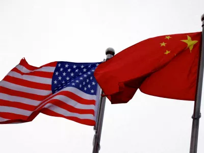 FILE PHOTO: Chinese and U.S. flags flutter outside the building of an American company in Beijing, China April 8, 2025. REUTERS/Tingshu Wang/File Photo