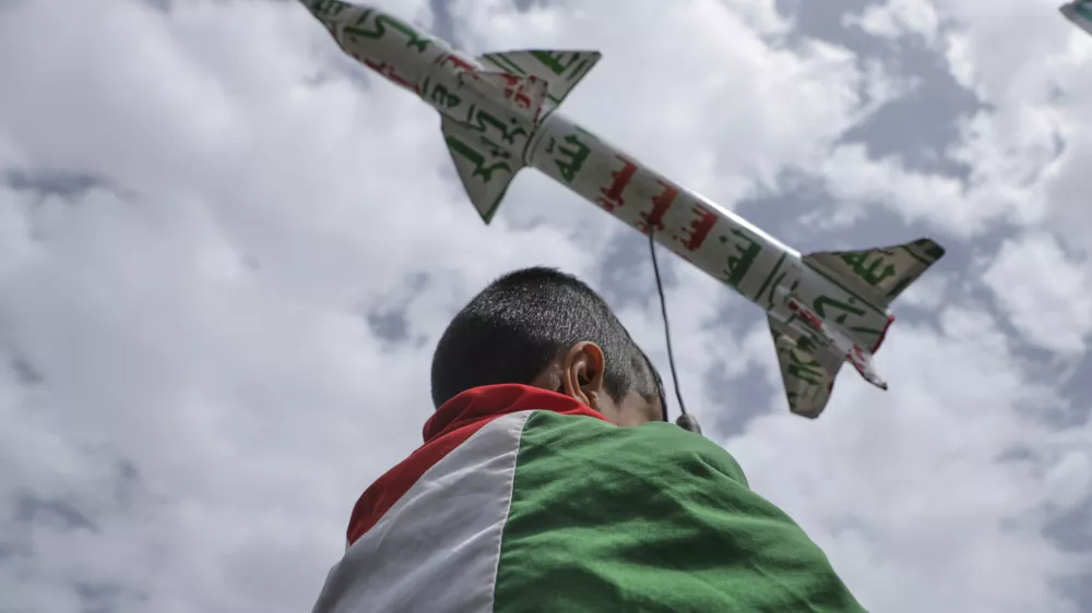 A boy draped in a Palestinian flag carries a mock rocket during a weekly anti-U.S. and anti-Israel rally organized by Houthi supporters in Sanaa, Yemen, Friday, May 9, 2025. (AP Photo/Osamah Abdulrahman)