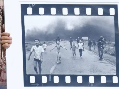 Pulitzer Prize-winning photographer Nick Ut (R), flanked by Kim Phuc, known as the 'Napalm Girl', shows his 1972 Vietnam war iconic photo as they wait to meet Pope Francis at the end of the weekly general audience in St. Peter s Square, Vatican on May 11, 2022.