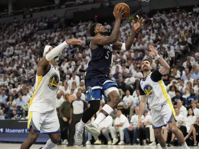 Minnesota Timberwolves guard Anthony Edwards (5) looks to shoot against Golden State Warriors' Pat Spencer, right, and Buddy Hield, left, during the second half of Game 5 of an NBA basketball second-round playoff series, Wednesday, May 14, 2025, in Minneapolis. (AP Photo/Abbie Parr)