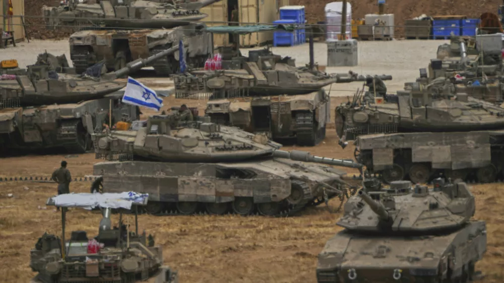 Israeli soldiers work on tanks and APCs at a staging area near the border with the Gaza Strip, in southern Israel, Thursday, May 15, 2025. (AP Photo/Ariel Schalit)
