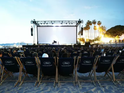 People sit ahead of a beach front cinema screening during the 78th Cannes Film Festival in Cannes, France, May 15, 2025. REUTERS/Stephane Mahe