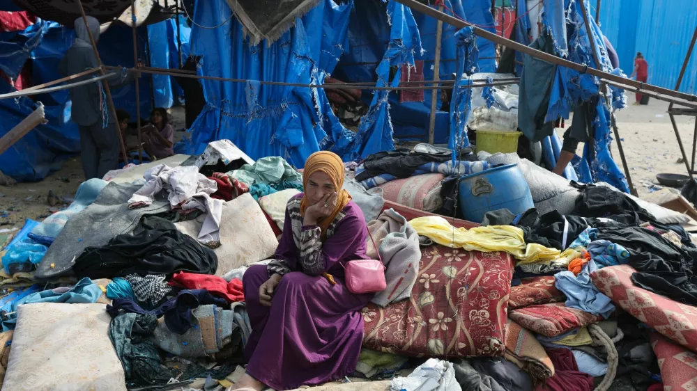 A Palestinian woman sits at the site of an Israeli airstrike on a tent sheltering displaced people, in Deir Al-Balah in the central Gaza Strip, May 17, 2025. REUTERS/Ramadan Abed