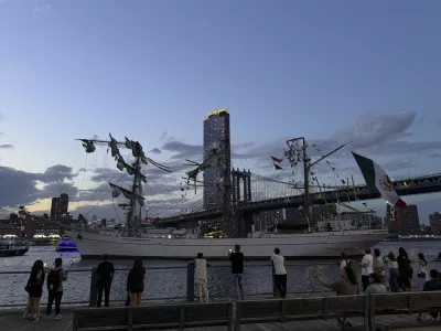 Pedestrians walking along Brooklyn Bridge Park look on as a masted Mexican Navy training ship sits stranded near the Manhattan Bridge after colliding with the Brooklyn Bridge, Saturday, May 17, 2025, in New York. (Nick Corso via AP)