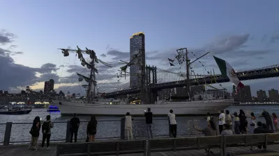 Pedestrians walking along Brooklyn Bridge Park look on as a masted Mexican Navy training ship sits stranded near the Manhattan Bridge after colliding with the Brooklyn Bridge, Saturday, May 17, 2025, in New York. (Nick Corso via AP)