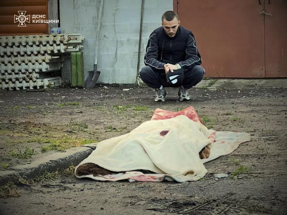 In this photo provided by the Ukrainian Emergency Service, a man reacts at the body of a killed resident following Russia's drone attack in the Kyiv region, Ukraine, Sunday, May 18, 2025. (Ukrainian Emergency Service via AP)