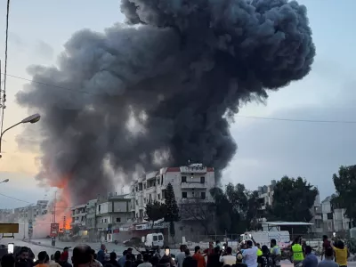 People gather as smoke billows near buildings following an Israeli strike after issuing an evacuation warning, in Toul, Nabatieh district, southern Lebanon, May 22, 2025. REUTERS/Ali Hankir   TPX IMAGES OF THE DAY