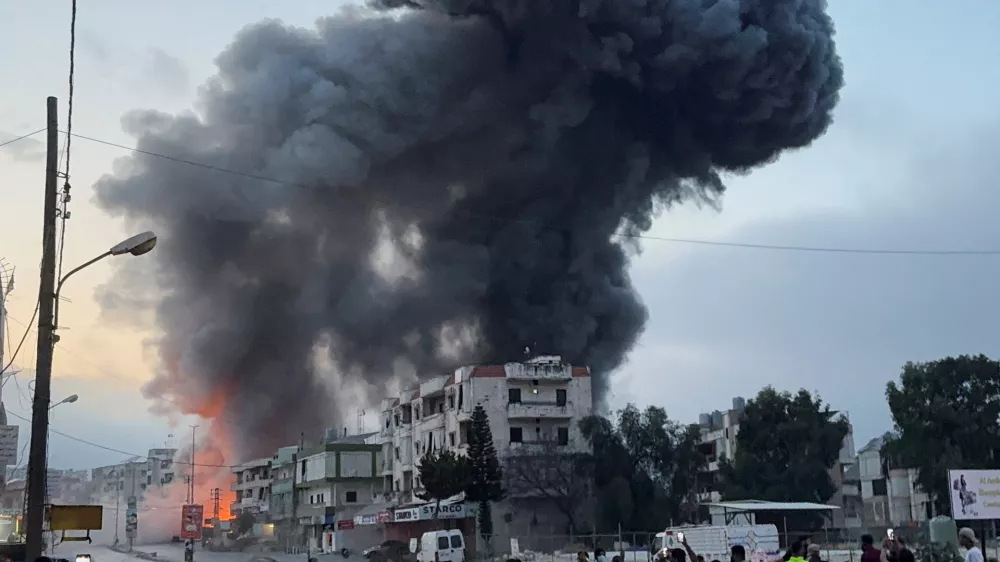 People gather as smoke billows near buildings following an Israeli strike after issuing an evacuation warning, in Toul, Nabatieh district, southern Lebanon, May 22, 2025. REUTERS/Ali Hankir   TPX IMAGES OF THE DAY