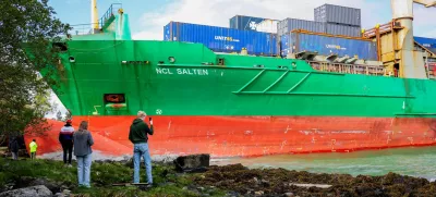 People stand near a container ship, which almost hit a house, in Trondheim, Norway, May 22, 2025. NTB/Jan Langhaug/via REUTERS  ATTENTION EDITORS - THIS IMAGE WAS PROVIDED BY A THIRD PARTY. NORWAY OUT. NO COMMERCIAL OR EDITORIAL SALES IN NORWAY.