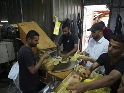 Palestinians bake bread after the World Food Program was able to bring in flour for the first time in over a month as Israel allowed some aid to enter the Gaza Strip, in Deir al-Balah, Gaza Strip, Thursday, May 22, 2025. (AP Photo/Abdel Kareem Hana)