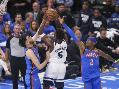 Minnesota Timberwolves guard Anthony Edwards, center, goes up for a basket against Oklahoma City Thunder forward Chet Holmgren, left, and guard Shai Gilgeous-Alexander during the second half of Game 2 of an NBA basketball Western Conference Finals playoff series Thursday, May 22, 2025, in Oklahoma City. (AP Photo/Nate Billings)
