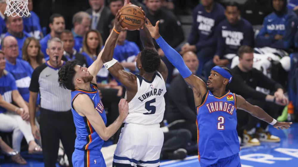 Minnesota Timberwolves guard Anthony Edwards, center, goes up for a basket against Oklahoma City Thunder forward Chet Holmgren, left, and guard Shai Gilgeous-Alexander during the second half of Game 2 of an NBA basketball Western Conference Finals playoff series Thursday, May 22, 2025, in Oklahoma City. (AP Photo/Nate Billings)