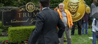 IMAGE DISTRIBUTED FOR OUR REVOLUTION - An activist calls out an attendee of an exclusive dinner at Trump National Golf Course as he and fellow activist from Our Revolution protest influence-peddling & corruption, Thursday, May 22, 2025 in Sterling, Va. Inside, the top 220 holders of the President's cryptocurrency have paid over 4 million for spots at an exclusive dinner with Trump. (Kevin Wolf/AP Content Services for Our Revolution)