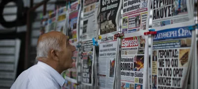 A man looks at the newspapers at a newsstand in central Athens, Monday, July 6, 2015. Greece's finance minister has resigned following Sunday's referendum in which the majority of voters said "no" to more austerity measures in exchange for another financial bailout. (AP Photo/Emilio Morenatti)