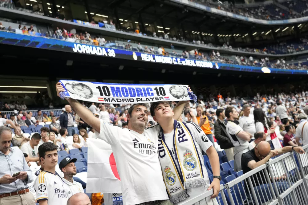 Real Madrid's fans hold banners with the name of Luka Modric as wait for the beginning of a Spanish La Liga soccer match against Real Sociedad at Santiago Bernabeu stadium in Madrid, Saturday, May 24, 2025. (AP Photo/Cesar Cebolla)