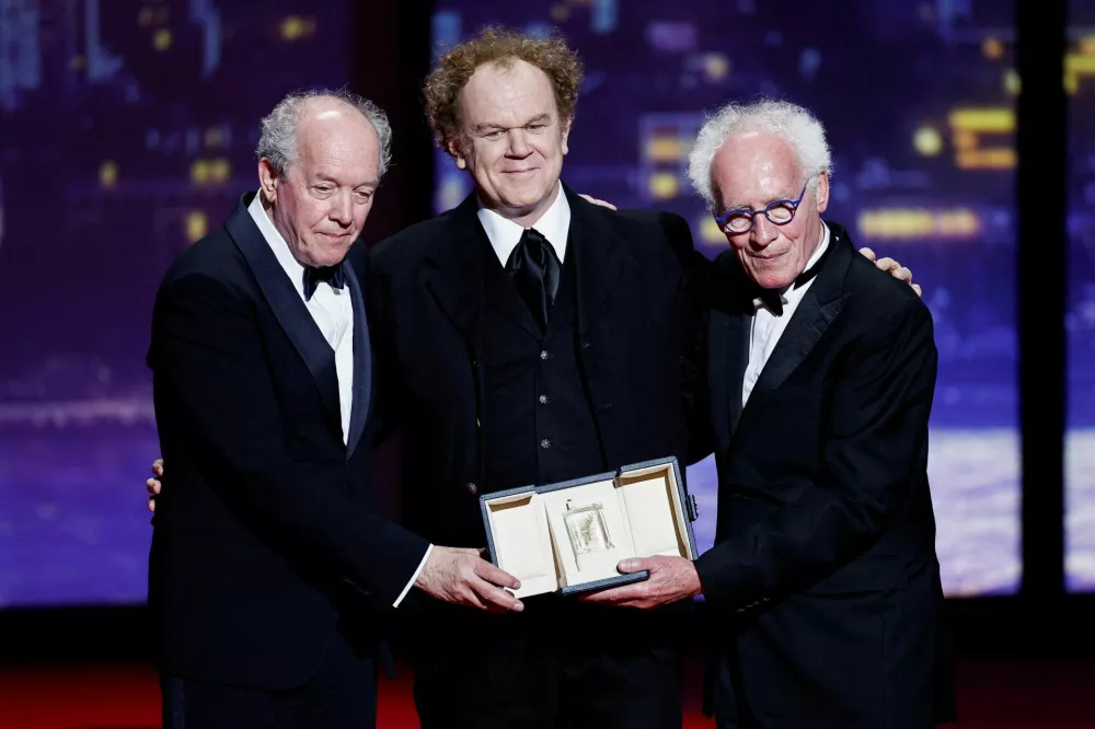 Directors Jean-Pierre Dardenne and Luc Dardenne receive the Best Screenplay award for the film "Jeunes meres" (Young Mothers) from John C. Reilly, during the closing ceremony of the 78th Cannes Film Festival in Cannes, France, May 24, 2025. REUTERS/Benoit Tessier   TPX IMAGES OF THE DAY