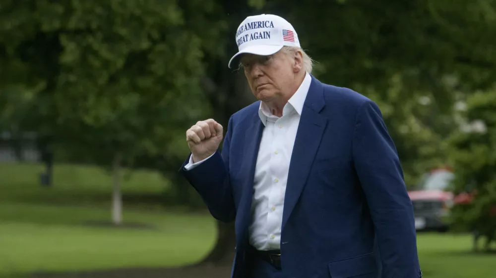 President Donald Trump acknowledges reporters as he disembarks Marine One upon arrival on the South Lawn of the White House in Washington, Sunday, May 25, 2025. (AP Photo/Rod Lamkey, Jr.)