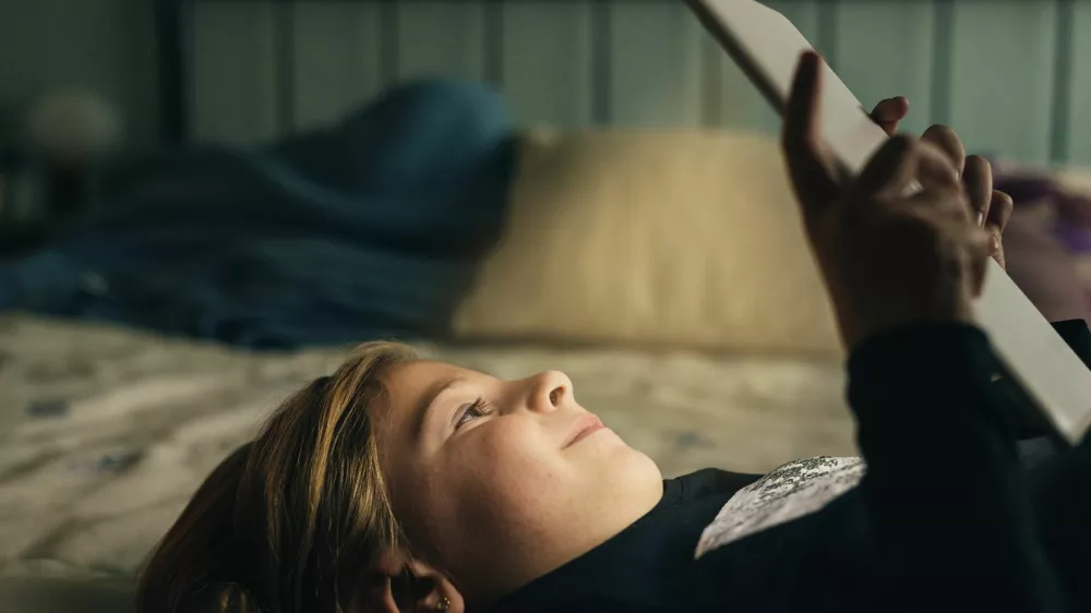 Sweet blondie girl playing on a Tablet PC.